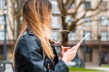 Genç hippi kız şehirde PC tableti tutuyor. Gezgin kadın tablet tablet üzerinde rehber kitap haritası kullanıyor, mobil internet kullanıyor. Kadın kısa mesaj ya da içerik mesajı yazıyor.