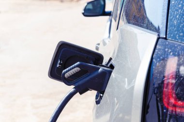 Elektrikli araba aküsüne şarj ediliyor. Elektrik pompası, modern teknolojiyle elektrikli araca şarj oluyor. Otomobil yakıt istasyonu, alternatif sürdürülebilir eko enerji kablolarına bağlı..