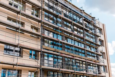 İnşaat iskelesi yenileme alanı. İnşaat alanının önündeki binanın dış görünüşü. Telsiai, Litvanya. 04-30-2023..