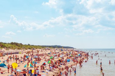 Deniz kenarındaki kalabalık plaj güneşli bir gün, kalabalık. Mavi gökyüzü sıcak yaz günü. Palanga-Litvanya, 27-2020.