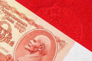 Eski Sovyet ruble banknotunda Lenin 'in portresi. 10 ruble SSCB' nin 10 ruble 'lik banknotunda Lenin resmi var. Kırmızı tekstil yüzeyi..