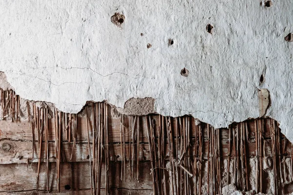 Crumbling plaster old wooden wall covered with plaster on the wall with wooden battens and old plaster, copy space, vintage, texture, wallpaper, geometric pattern with a rhombus.