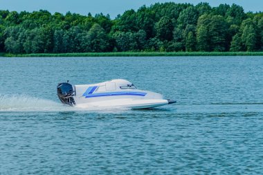 Sürat teknesi göl boyunca sürat teknesi yarışında, yarışmada, turnuvada hızlı gider..