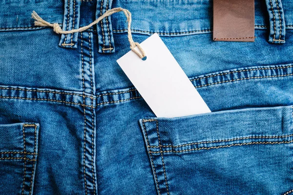 ブルーデニムジーンズのラベルタグモックアップ ブルーデニムジーンズ ベルト 革ベルト付きジーンズパンツ ラベル ステッカー — ストック写真