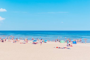 Deniz kenarındaki kalabalık plaj güneşli bir gün, kalabalık. Mavi gökyüzü sıcak yaz günü. Palanga-Litvanya, 27-2020.