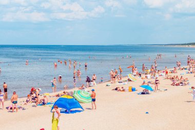 Deniz kenarındaki kalabalık plaj güneşli bir gün, kalabalık. Mavi gökyüzü sıcak yaz günü. Palanga-Litvanya, 27-2020.