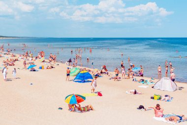 Deniz kenarındaki kalabalık plaj güneşli bir gün, kalabalık. Mavi gökyüzü sıcak yaz günü. Palanga-Litvanya, 27-2020.