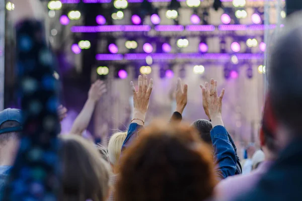 stock image A festival crowd raising their hands.Party people at a concert.Rear view.