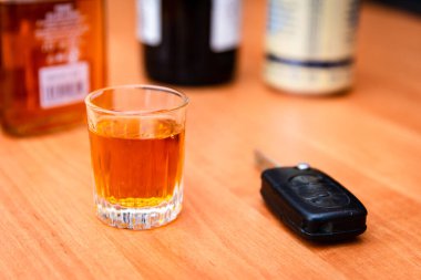 Sarhoş araba kullanmak. İçki ve araba anahtarı. Masada bir bardak viski ve araba anahtarı. Araba kullanmak ya da kullanmamak..