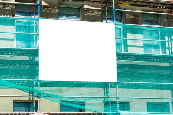 用脚手架在正在建造的大楼的墙上用复制空间模仿户外广告 正在整修的大楼正面的空白信息板 — 图库照片