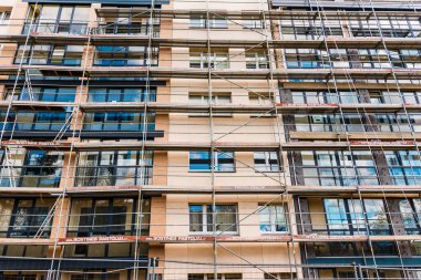 İnşaat iskelesi yenileme alanı. İnşaat alanının önündeki binanın dış görünüşü. Telsiai, Litvanya. 04-30-2023..