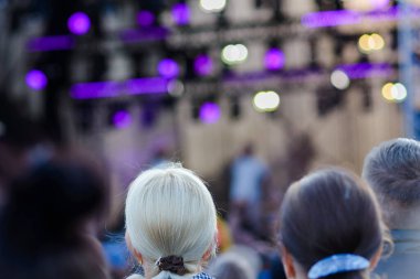 Açık havada genç sarışın kadın Müzik Festivali 'nde kutlama yapıyor.