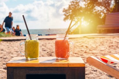 Tropikal sahilde iki taze meyve suyu. Lüks tropik yaz plajlarında kokteyller. Gün batımı ya da gün doğumu..