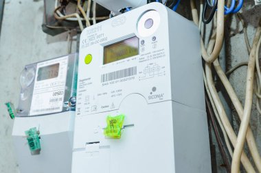 Akıllı elektrik sayacı güç kullanımını ölçüyor. Modern akıllı şebeke yerleşim birimi dijital güç sayacına yakın çekim. İç mekanda. Telsiai, Litvanya. 07-12-2023.