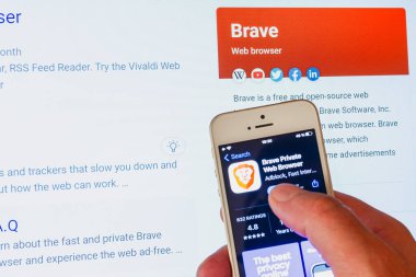 Logolu Cesur Tarayıcı mobil uygulaması. Arka planda cesur ekran. Brave, Brave Software, Inc.Telsiai, Litvanya 'da geliştirilen özgür ve açık kaynak web tarayıcısıdır..