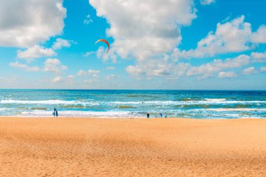 Yaz tatili, deniz manzarası ve bir paraglider ile plaj. Yaz plajında tatil yapan turistler. Klaipeda, Litvanya 07-14-2023.