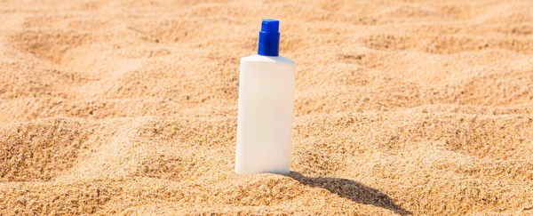 Sunscreen cream bottle on the beach.Design cosmetic product template mockup for sunblock cosmetics. Sunscreen cream on a summer beach.