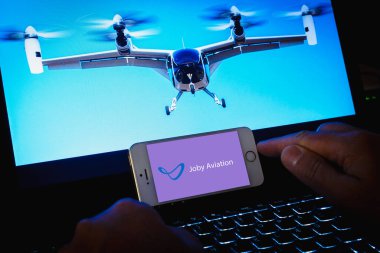 Joby Havacılık logosu. Akıllı telefon tutan kişi. Joby Havacılık, hava taksi servisleri için elektrikli uçak üreten bir ABD şirketidir. Telsiai, Litvanya. 08-09-2023.