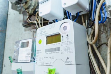Akıllı elektrik sayacı güç kullanımını ölçüyor. Modern akıllı şebeke yerleşim birimi dijital güç sayacına yakın çekim. İç mekanda. Telsiai, Litvanya. 07-12-2023.