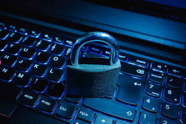 Cyber Security Concept.Iron padlock,lock on laptop computer illuminated keyboard.Toned,selective focus,close-up,
