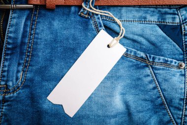 Mavi kot pantolon, kemer, deri kemerli pantolon etiketi, etiket, etiket, etiketi, etiketi boş beyaz boşluk, yakın çekim. Boşluğu kopyala..