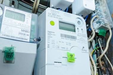 Akıllı elektrik sayacı güç kullanımını ölçüyor. Modern akıllı şebeke yerleşim birimi dijital güç sayacına yakın çekim. İç mekanda. Telsiai, Litvanya. 07-12-2023.
