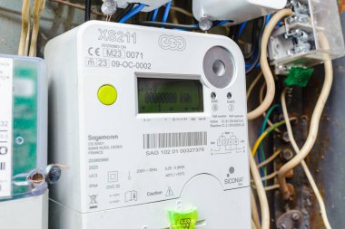 Akıllı elektrik sayacı güç kullanımını ölçüyor. Modern akıllı şebeke yerleşim birimi dijital güç sayacına yakın çekim. İç mekanda. Telsiai, Litvanya. 07-12-2023.