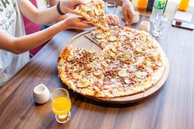 Gençler pizzacıda parça parça pizza yiyorlar..