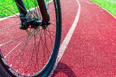 Yolda bir bisikletçi var. Bisikletli biri, kırmızı bir arka planda yukarıdan bisiklete biniyor. Yakından. Telsiai, Litvanya. 09-13-2023..