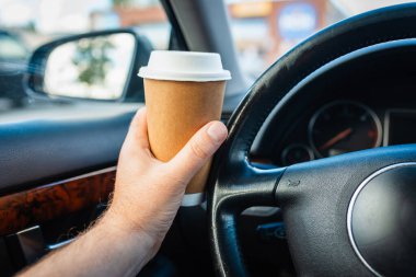 Ulaşım ve araç trafiği sıkışıklığı kavramı. Trafik sıkışıklığında sabah araba kullanırken elinde kağıt bardak sıcak kahve içen biri..