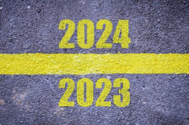 2023 'ten 2024' e yeni yıl kavramı. Yüzey grunge of asfalt, pürüzsüz asfalt rengi, yolda sarı çizgili koyu gri. Doku Arka plan. Arka plan için Doku. Kapalı görünüm..