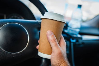 Ulaşım ve araç trafiği sıkışıklığı kavramı. Trafik sıkışıklığında sabah araba kullanırken elinde kağıt bardak sıcak kahve içen biri..