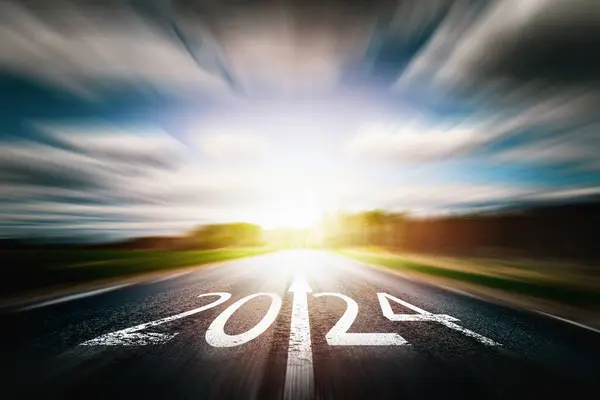 New year 2024 concept. Text 2024 written on the road of asphalt road at sunset.Concept of planning and challenge, business strategy, opportunity ,hope, new life change.highway with blurred motion.