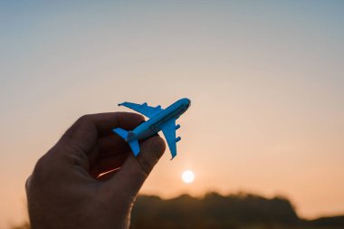 Oyuncak uçak tutan ve hayalleri olan bir adamın elleri pilot olmak ister. Arkaplanda bulanık bulutlar, mavi gökyüzü..