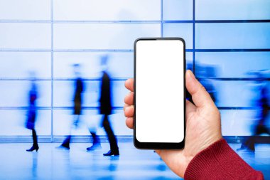 Beyaz ekranlı, modern akıllı telefonu elinde tutan bir erkek. İş adamları sokakta yürüyor. Mesaj ya da içerik için hazırlar. Cep telefonlu bir adam..