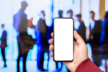 Beyaz ekranlı, modern akıllı telefonu elinde tutan bir erkek. İş adamları sokakta yürüyor. Mesaj ya da içerik için hazırlar. Cep telefonlu bir adam..