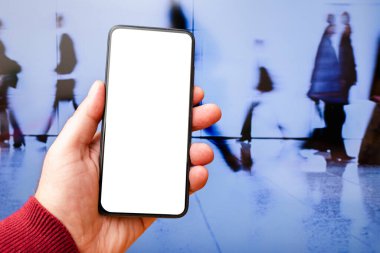 Boş beyaz ekran cep telefonunu modelle. Akıllı telefon kullanan bir iş adamı. Bulanık şehirli iş adamları sokağı.