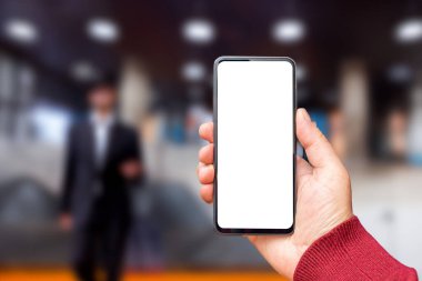 Akıllı telefondan oluşan boş bir beyaz ekran. Logonuz ya da tasarımınız için şablon ekranlı modern siyah cep telefonu taşıyan bir erkek el..