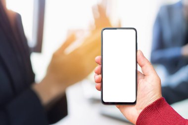 Akıllı telefondan oluşan boş bir beyaz ekran, modern siyah cep telefonuyla logo, tasarım, alkış, alkışlama, ofis arka planınız için şablon ekranı olan bir erkek eli..