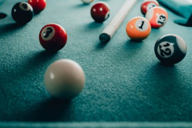 Yeşil elbiseli bir bilardo oyunu. İçinde numaralar, bilardo topu ve bilardo masasının üzerinde üçgen olan çok renkli bilardo topları. Bilardo toplarını yakın çekim..