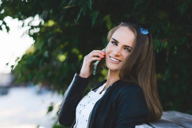 Halka açık parkta cep telefonuyla konuşan güzel bir kadın..