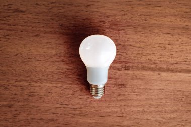 Tahta masa üzerinde LED ampul. Enerji tasarrufu kavramı..