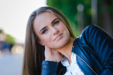 Açık havada gülümseyen genç bir kadın portresi. Yumuşak güneşli renkler. Kapalı portre. Güzel bir gün..