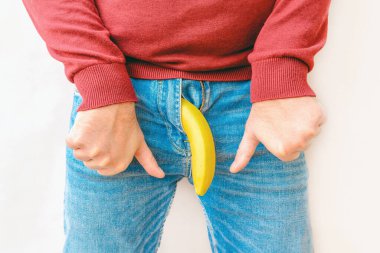İktidar sorunu kavramı. Muz taklidi yapan erkek pantolonu. El baş parmakları gösteriyor. Sağlık ve erkek cinselliği kavramı..