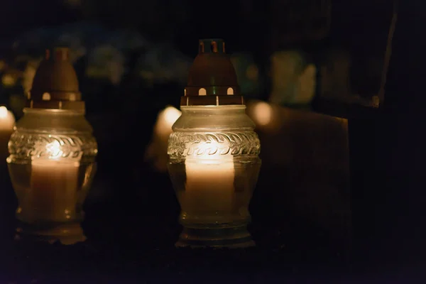 Memory lantern with burning candle in the dark.White Candles Burning in the Dark Night with lights glow.Focus on candles in foreground.