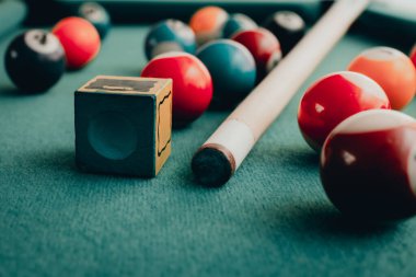 Yeşil elbiseli bir bilardo oyunu. İçinde numaralar, bilardo topu ve bilardo masasının üzerinde üçgen olan çok renkli bilardo topları. Bilardo toplarını yakın çekim..