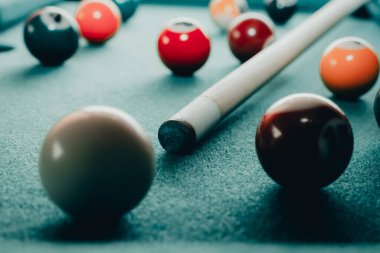 Yeşil elbiseli bir bilardo oyunu. İçinde numaralar, bilardo topu ve bilardo masasının üzerinde üçgen olan çok renkli bilardo topları. Bilardo toplarını yakın çekim..