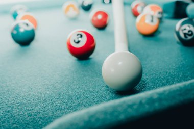 Yeşil elbiseli bir bilardo oyunu. İçinde numaralar, bilardo topu ve bilardo masasının üzerinde üçgen olan çok renkli bilardo topları. Bilardo toplarını yakın çekim..