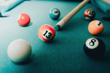 Yeşil elbiseli bir bilardo oyunu. İçinde numaralar, bilardo topu ve bilardo masasının üzerinde üçgen olan çok renkli bilardo topları. Bilardo toplarını yakın çekim..