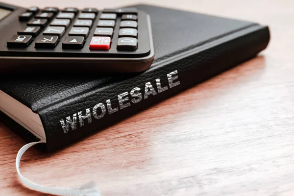 Wholesale business black book,calculator on the office wooden table.Closeup,selective focus.